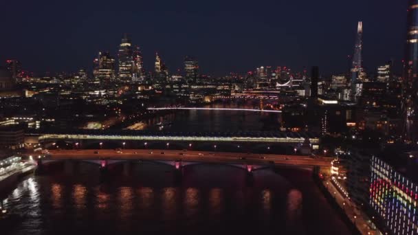 W nocy przelatują nad rzeką Tamizą. Widok z lotu ptaka na kolorowe światła miejskie świecące w ciemności. Londyn, Wielka Brytania — Wideo stockowe