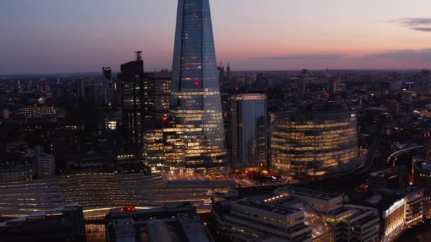 ロンドン・ブリッジ駅の夕景。照らさ屋根のプラットフォームと周辺のオフィスビル。イギリスのロンドン — ストック動画