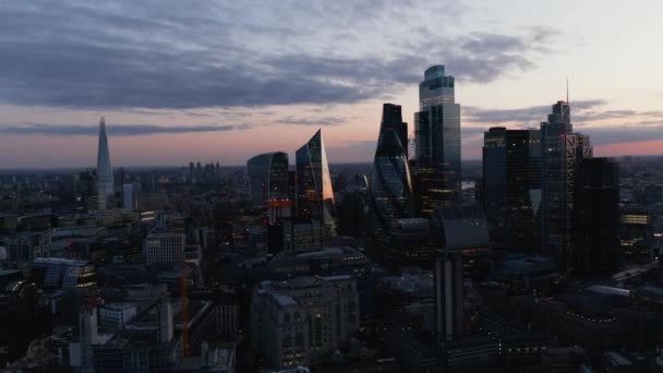 Scivolo e pan shot di gruppo di grattacieli nel quartiere degli affari della città. Edifici alti e futuristici contro il cielo crepuscolare. Londra, Regno Unito — Video Stock