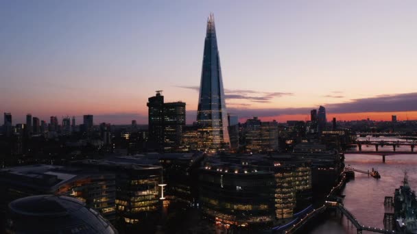 En avant survolez la ville du soir. En direction du gratte-ciel Shard. Grand immeuble de bureaux moderne contre ciel crépusculaire coloré. Londres, Royaume-Uni — Video