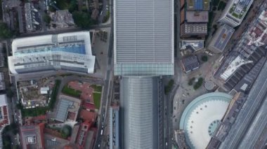 Gökyüzü kuşları tepeden aşağı şehirdeki binaların manzarasını izliyorlar. St Pancras tren istasyonunun büyük çatısı ve tren yolunu takip ediyor. Londra, İngiltere