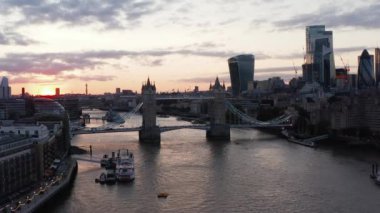 Gün batımına karşı ünlü tarihi Tower Köprüsü 'nün slayt ve pan görüntüleri. Thames Nehri kıyısındaki yüksek modern binalar. Londra, İngiltere