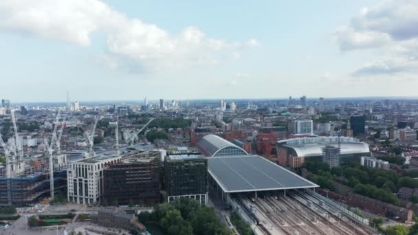 Группа кранов на строительной площадке рядом с вокзалом Сент-Панкрас. Воздушный панорамный вид на город с современными небоскребами на расстоянии. Лондон, Великобритания — стоковое видео