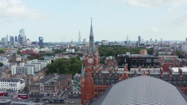 Stacja kolejowa St Pancras z zabytkową wieżą zegarową. Widok panoramiczny na panoramę miasta z drapaczami chmur w tle. Londyn, Wielka Brytania — Wideo stockowe