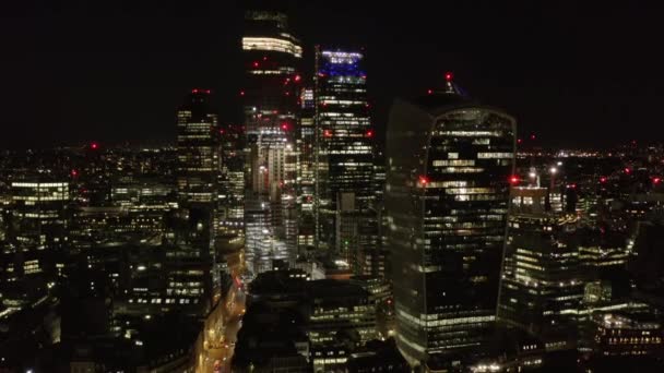 Vista elevata di gruppo di edifici alti e moderni nel centro finanziario ed economico della città di notte. Avanti volate verso i grattacieli. Londra, Regno Unito — Video Stock