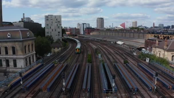 Seguimiento hacia atrás de la conducción de trenes de pasajeros en un amplio puente ferroviario multivía sobre el río. Londres, Reino Unido — Vídeos de Stock