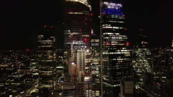 Indietro rivelano di grattacieli nel distretto finanziario della città. Ritirate i filmati di un cantiere illuminato con gru a torre. Londra, Regno Unito — Video Stock