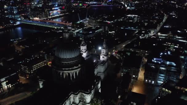 夜间俯瞰著名的圣保罗大教堂.滑行和平底锅射击。泰晤士河，照亮背景中的桥梁。London, UK — 图库视频影像