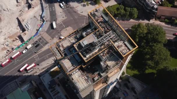 High angle view of top of skyscraper with crane and scaffolding. Construction site on top, repairing or maintenance. Descending footage. London, UK — Stock Video