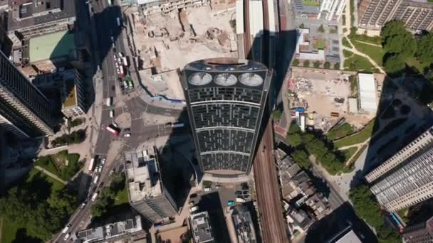 Vista aérea de las aves vista desde arriba hacia abajo del rascacielos moderno de Strata con turbinas eólicas integradas en el edificio. Tráfico en las calles, vehículos que conducen a través de la intersección de carreteras. Londres, Reino Unido — Vídeo de stock