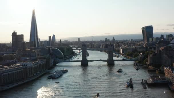 テムズ川にかかるタワーブリッジ。後方の水辺の建物を明らかにする。太陽の光を見る。イギリスのロンドン — ストック動画