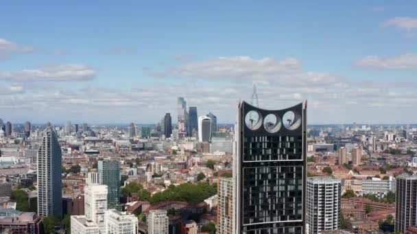 Avanti volare intorno grattacielo moderno con turbine eoliche nella parte superiore della costruzione. Rivelando vista panoramica della città con gruppo di alti edifici per uffici. Londra, Regno Unito — Video Stock