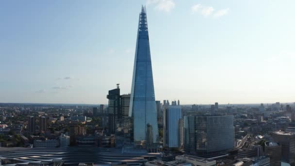 未来的なデザインの背の高いシャード超高層ビルのスライドとパンの映像。ロンドン・ブリッジ駅の隣にある高さのある近代的なオフィスビル。イギリスのロンドン — ストック動画