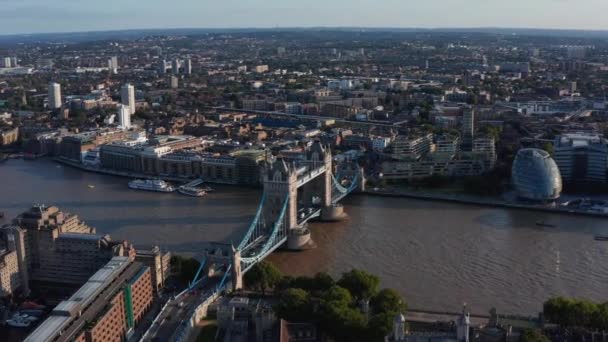 Panoramiczny widok na słynny zabytek, Tower Bridge przez rzekę Tamizę. Budynki w dużym mieście w godzinach wieczornych złota godzina. Londyn, Wielka Brytania — Wideo stockowe