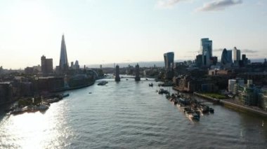 Thames Nehri 'nin panoramik görüntüleri ve her iki yakadaki gökdelenler yükseliyor. Su yüzeyi güneş ışığını yansıtıyor. Londra, İngiltere