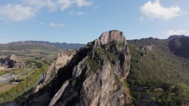 Altında dolambaçlı bir nehir bulunan engebeli bir dağ sırasının havadan görünüşü doğanın saf güzelliğini gözler önüne seriyor..