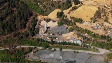 Ormandaki bir taş ocağının hava görüntüsü endüstriyel aktivite ve doğal çevre arasındaki zıtlığı vurguluyor..