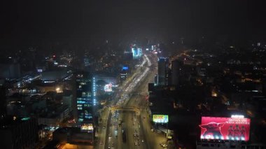 Peru 'daki Lima şehir merkezinin gece hava görüntüsü. Şehir manzarası yoğun otoyol trafiği ve aydınlık gökdelenleri gösteriyor..