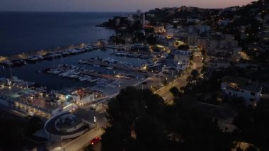 İspanya 'nın Mallorca kentindeki aydınlık şehrin manzarası. Alacakaranlıkta limana demirlemiş tekneler ve sakin bir gökyüzü..