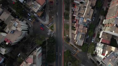 Lima, Peru 'da bir sokak kavşağında yüksek irtifa ile aşağı doğru uçan bir hava çekimi. Şehir trafiğinde hareket eden araba ve taksiler.