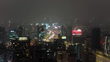 Modern gökdelenler ve ofis binaları Lima, Peru üzerinde puslu gece gökyüzünü aydınlatıyor. Yüksek görüş açısına sahip otoyollarda yoğun trafik akışı.