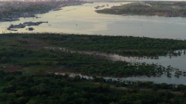 Günbatımında Amazon Nehri 'nin havadan görünüşü, Iquitos şehrinin genişliğini ve Peru' daki canlı yağmur ormanlarını yakalıyor..