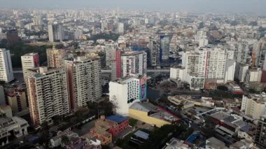 Lima, Peru 'nun kentsel manzarasını gösteren hava görüntüleri. Puslu bir günde şehri kaplayan yüksek binalar ve yerleşim alanları.