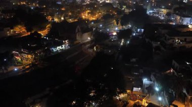 Peru, Lima 'nın aydınlık yerleşim bölgesinde gece uçan hava görüntüleri alçak evleri ve uzak gökdelenleri gösteriyor..