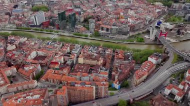 Bilbao 'nun geniş hava manzarası şehirlerin kompakt binalarını, Nervion Nehri' ni, sokak planlarını, uzaktaki yeşil dağları gösteriyor..