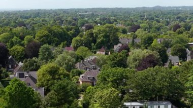 Huzurlu şehir manzarası yaratan evler ve yemyeşil ağaçlarla Hamburg 'un varoş semtindeki lojistik hava perspektifi