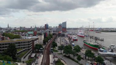 Almanya 'nın Hamburg kenti üzerindeki hava perspektifi, tarihi gemiler, Elbphilharmonie ve şehir trafiği ile dolu limanı gösteriyor.