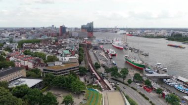 Hamburg, Almanya üzerinde hava görüntüleri. Red U Bahn treni Elbe nehri ve limanı yakınlarındaki Baumwall istasyonuna varmak üzere.