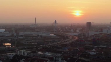 Mannheim 'ın Almanya' daki kentsel manzarasını gösteren hava perspektifi. Şehrin üzerinde güneş batıyor, binalara ve trafiğe sıcak bir ışık saçıyor..