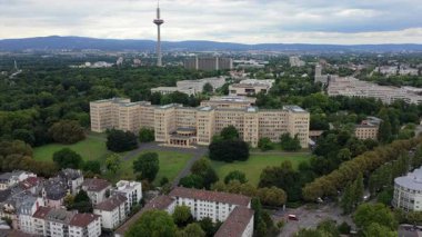 Goethe Üniversitesi Batı Kampüsü 'nün ikonik mimarisini arkaplanda Europaturm ile gösteren etkileyici bir hava çekimi.