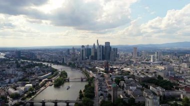 Frankfurt 'un ana finans bölgesinin hava perspektifi, bulutlu bir günde modern gökdelenleri, ana nehri ve şehir manzarasını sergiliyor.