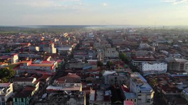 Peru 'daki Iquitos şehrinin hava perspektifi günbatımında geniş Amazon yağmur ormanlarıyla çevrili şehir manzarasını gösteriyor..