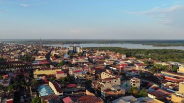 Peru Amazon 'unun en büyük şehri olan Iquitos' un günbatımında yağmur ormanları arka planında mimari ve şehir planlarını gösteren hava görüntüleri..