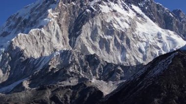 Nepal 'deki Himalayalar' da sabah erken saatlerde açık gökyüzü ile yakalanan karla kaplı bir dağın nefes kesici manzarası..