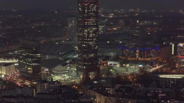 Messeturm ve hareketli şehir sokak lambaları da dahil olmak üzere aydınlık gökdelenlerin yer aldığı Frankfurt Fuarı 'nın gece hava manzarası.