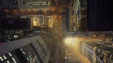 Geceleri Frankfurt finans bölgesinin yukarıdan aşağı görüntüsü. Gökdelenlerin, çatıların ve aydınlatılmış ofis binalarının üzerinde uçuyor..