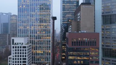 Frankfurt, Almanya 'nın merkezindeki yüksek katlı ofis binalarından geçen hava manzarası. Aydınlatılmış pencereler kentleri, işlek bankacılık ve iş merkezlerini gözler önüne seriyor.