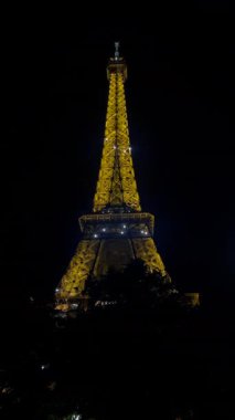 Paris 'teki Eyfel Kulesinin Gece Işığı, Karanlık Gökyüzüne Karşı Görkemli İkonik Simgeler Parıltısı.