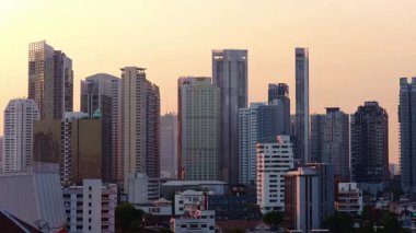 Bangkoks 'un modern siluetinin görüntüsü. Yüksek binalar ve modern mimari güzel, sıcak bir günbatımı gökyüzüne karşı..