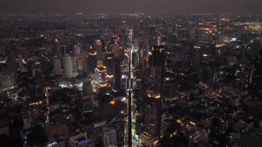 Geceleri Bangkok 'un gökdelenleri ve hareketli şehir hayatı ile dolu havadan görünüşü Tayland başkentlerinin modern ufuk çizgisini sergiliyor..