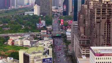 Havadan bakıldığında Bangkok, Tayland manzarası görülüyor. Gökdelenler ve şehir parklarıyla çevrili sokaklar boyunca yoğun trafik hareketleri.