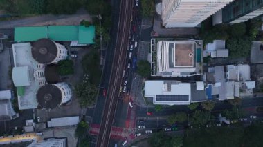 Bangkok, Tayland 'dan geçen caddeleri ve demiryolu hattını izleyen hava perspektifi. Modern binalar ve yemyeşil bir golf sahası işlek sokak trafiğinin etrafını sarıyor..