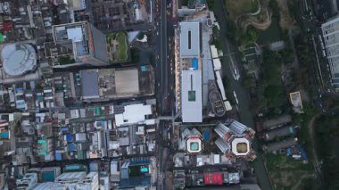 Bangkok kentinin kuş bakışı perspektifi işlek sokakları, modern binaları ve tekne trafiği olan dolambaçlı bir kanalı gösteriyor.