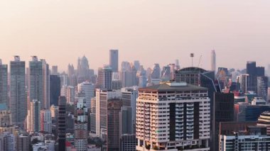 Tayland 'ın başkenti Bangkok' un havadan görünüşü. Kalabalık şehir manzarasını gökdelenler ve kulelerle aydınlatan puslu gün batımı.