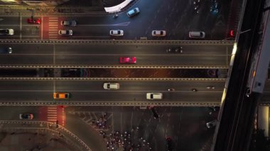 Bangkok, Tayland 'daki yoğun kavşağın yukarıdan görünen görüntüsü, gece, arabalar, motosikletler ve gökyüzü treniyle şehirde ilerliyor..
