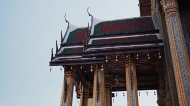 Bangkok, Tayland 'daki bir Budist tapınağının süslü altın sütunları ve renkli katlı çatısı. Dini mimari ve kültürel dönüm noktası.